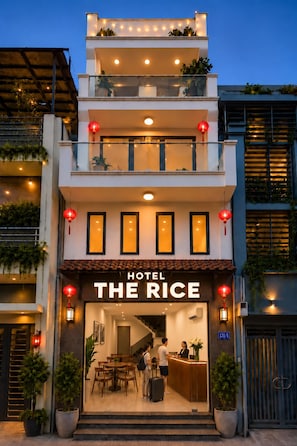 A hotel entrance with a sign reading 'HOTEL THE RICE,' a reception desk, and a staircase leading to the upper floors. - The Rice Hotel - Ben Thanh (Ho Chi Minh City)