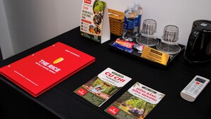 A table with brochures, a red folder, a water dispenser, and a coffee maker. - The Rice Hotel&Tour - 39 Nguyen Trai No4 (Ho Chi Minh City)