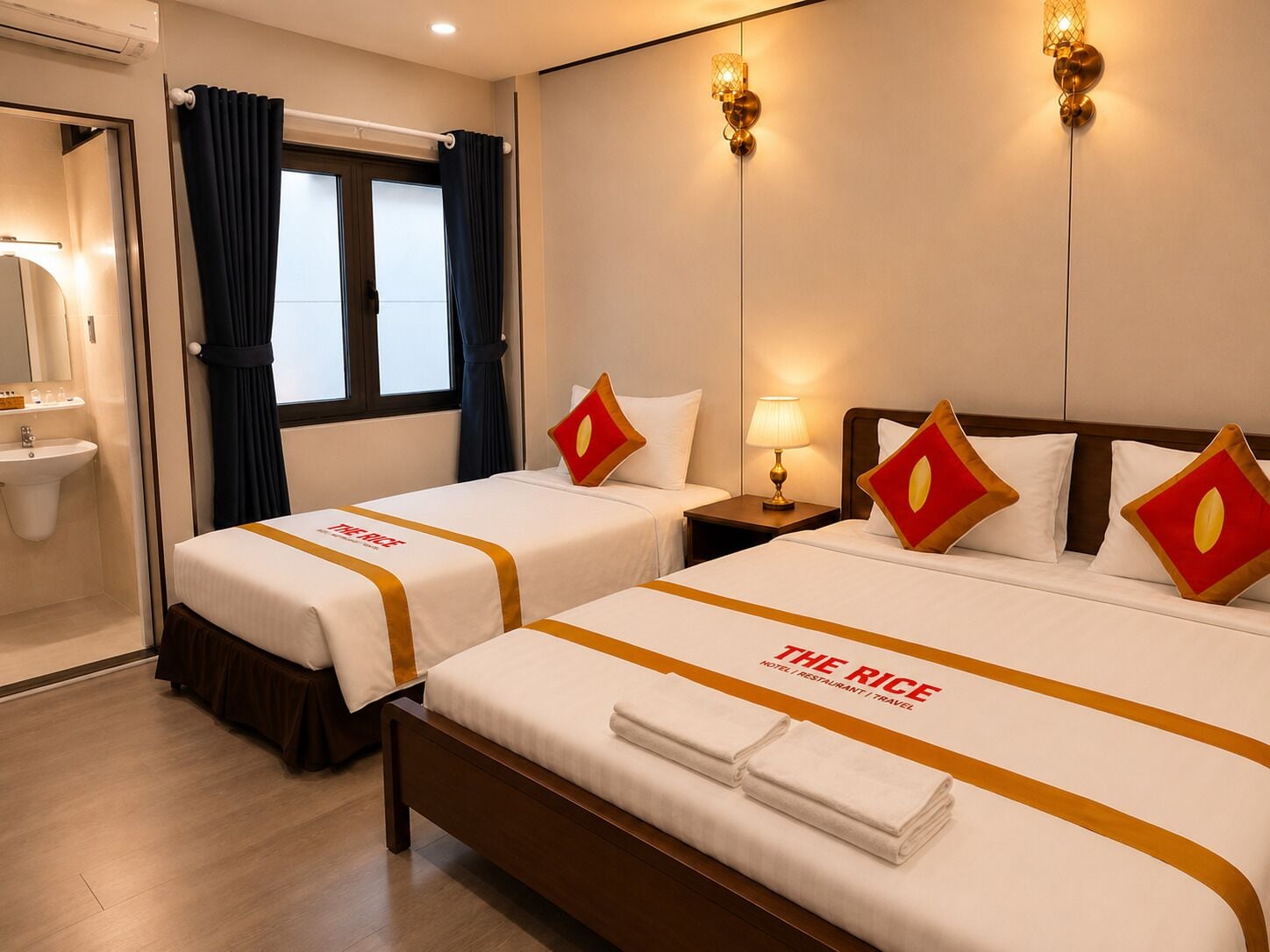 Habitación de hotel con dos camas, una mesita de noche, una lámpara, una ventana con cortinas y un lavamanos.