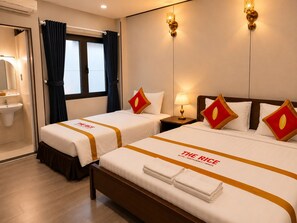 Een hotelkamer met twee bedden, een nachtkastje, een lamp, een raam met gordijnen en een wastafel.