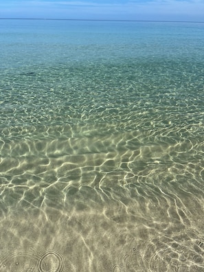 Clear shallow water with visible sand patterns. - "Sunshine, Peace & Tranquility" (Negril)