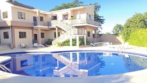 A two-story building with a swimming pool, outdoor seating, and a staircase leading to the upper level. - "Sunshine, Peace & Tranquility" (Negril)