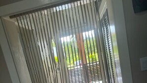 A doorway with a metal gate, a white wall, and a view of a green outdoor area. - "Sunshine, Peace & Tranquility" (Negril)