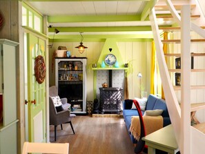 A cozy living room with a sofa, a chair, a bookshelf, and a decorative plate on the wall. - Authentic fisherman's house in the heart of Edam (Edam)