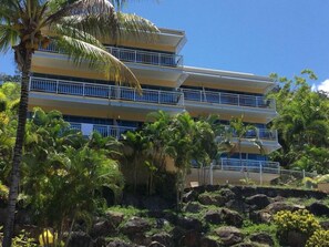 A multi-story hotel with balconies, surrounded by tropical vegetation. - Coral Sea Vista Apartments (Airlie Beach)