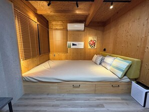 A bedroom with a wooden ceiling, a bed with pillows, a bedside table, and a radiator. - REN HANARE Hakuba (Hakuba)