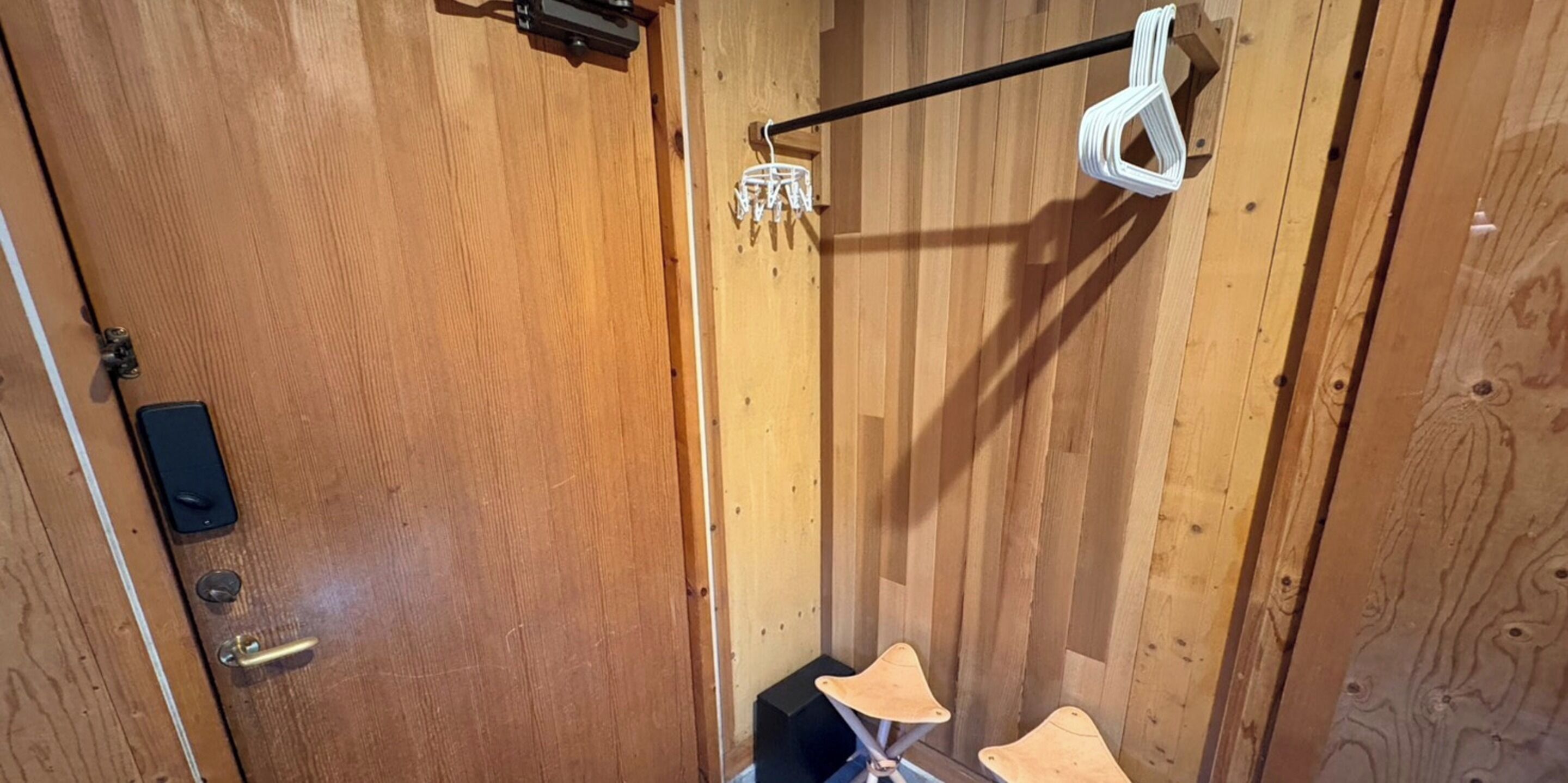 A wooden door with a keyhole, a lock, and a small electronic device.