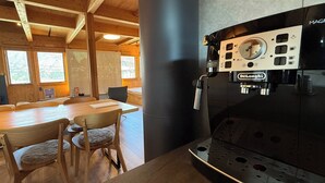 A wooden interior with a coffee machine, wooden tables, and chairs. - REN HANARE Hakuba (Hakuba)
