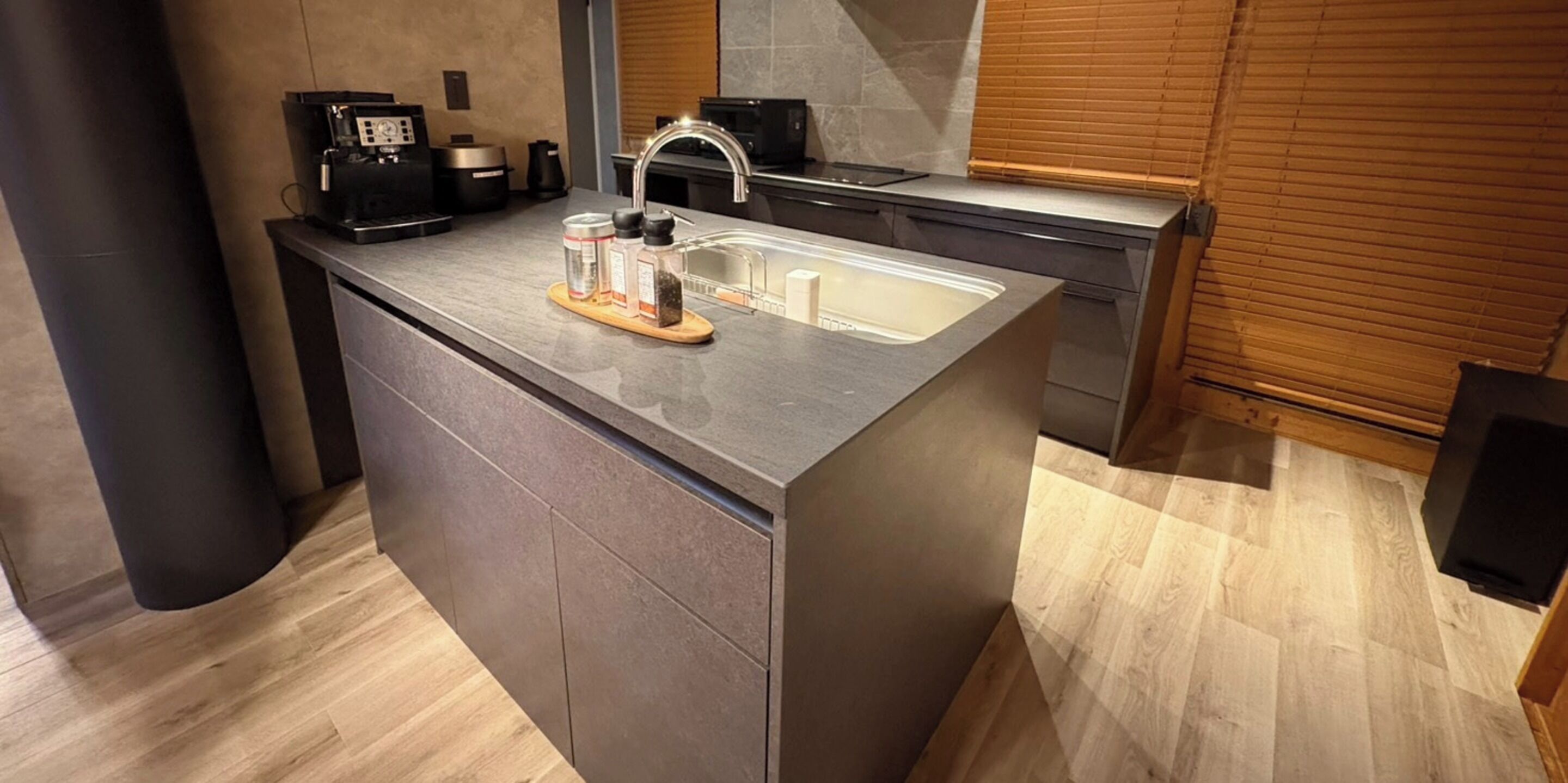 A modern kitchen with a built-in island, a coffee machine, and a sink.
