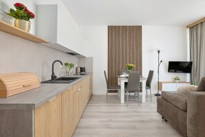 Una cocina moderna con estufa integrada, encimera de madera y comedor con mesa y sillas.