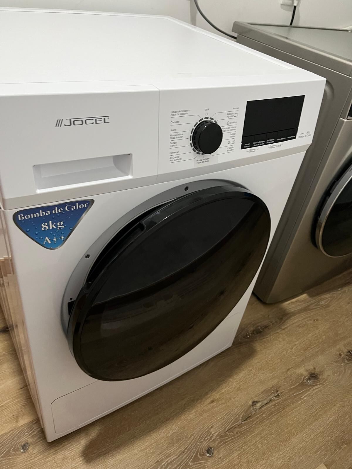 A white washing machine with a control panel and a label indicating a 8kg capacity.
