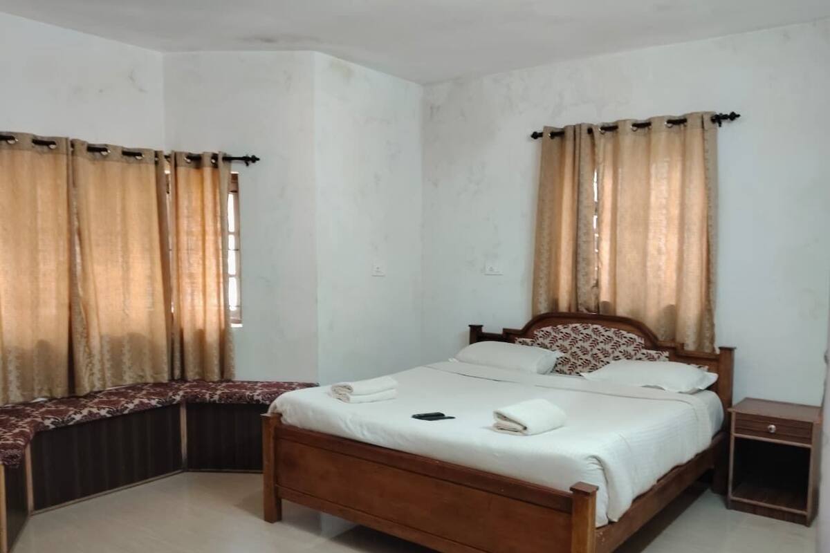 Un dormitorio con una cama de madera, una mesita de noche y cortinas.