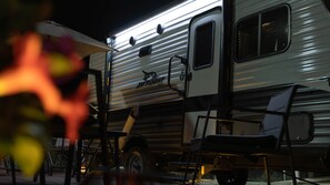 A motorhome with a 'Jay Flight' logo, a ladder, and a table.