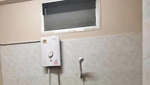 A bathroom with a shower, a toilet, and a window. - Nanas Apartment Pattaya (Muang Pattaya)
