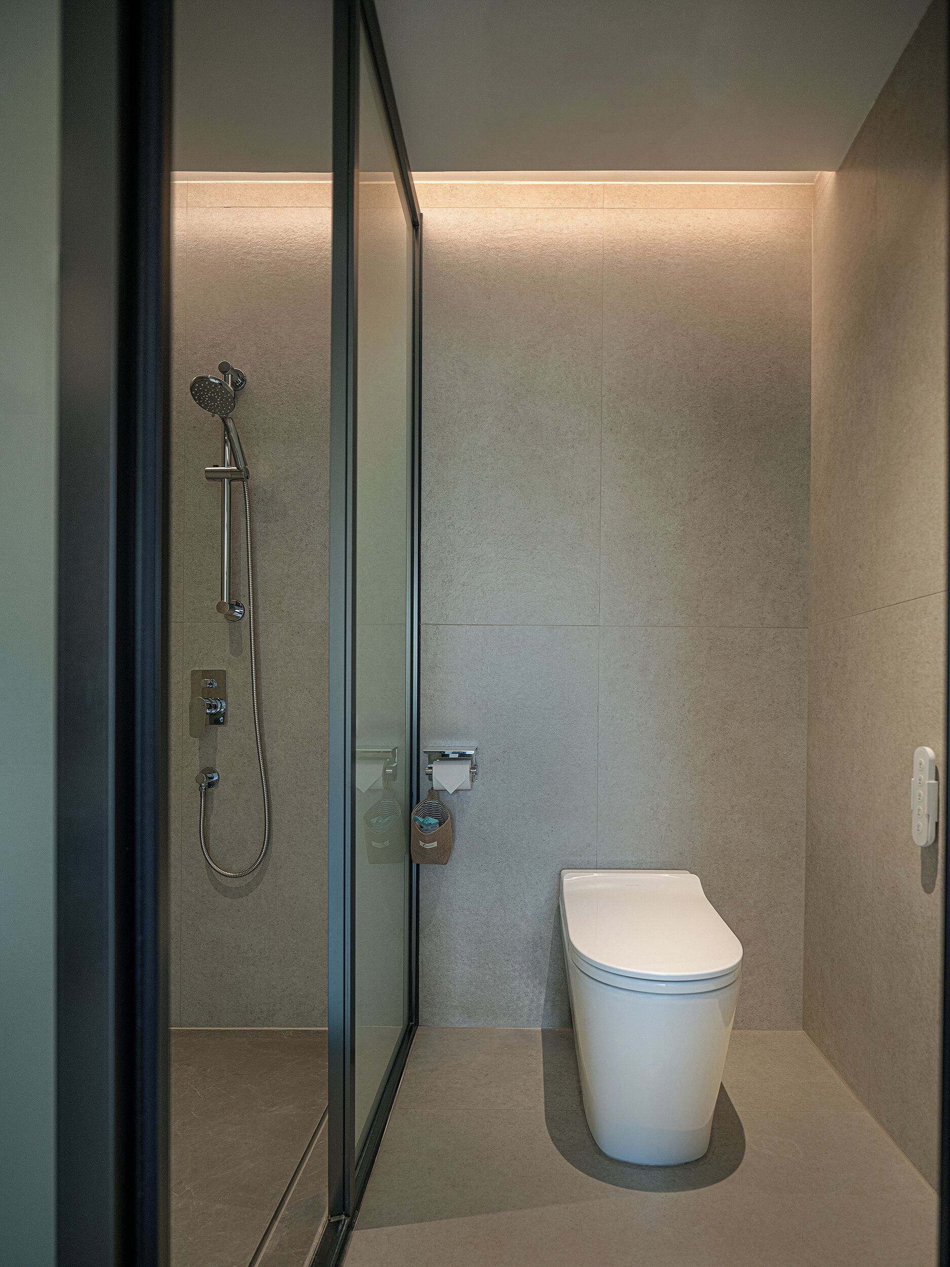 Une salle de bain moderne avec une douche à parois de verre, des toilettes et un porte-serviettes.