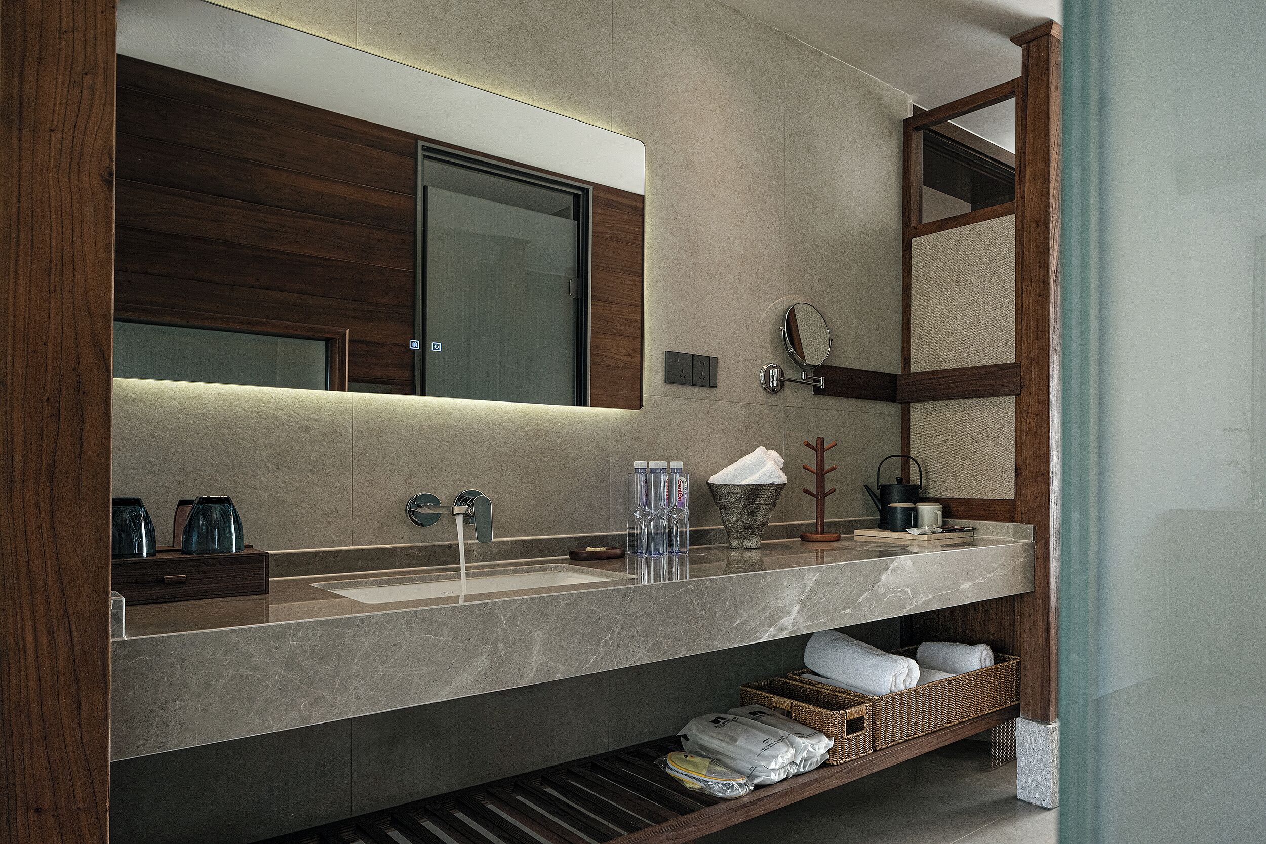 A modern bathroom with a large mirror, a sink, and a towel rack.