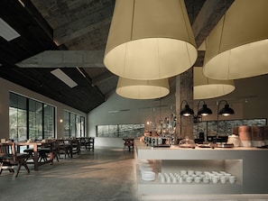 A spacious room with large windows, a long table with chairs, and a counter with kitchen appliances. - Zhangjiajie national park Oxgen Resort (Zhangjiajie)