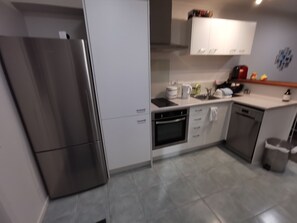 A modern kitchen with stainless steel appliances, white cabinetry, and a tiled backsplash. - *Quiet, Cozy & Family-Friendly | Pool, Gym, Shops & Transport Nearby (Northshore)