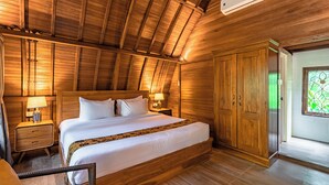 A wooden-paneled room with a large bed, bedside tables, a wardrobe, and a window with a green view. - Pada Wareg Villas, Ubud by Sidhi Hospitality Experiences (Gianyar)