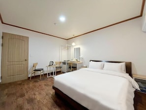 A hotel room with a bed, a desk, a chair, a wardrobe, and a mirror. - METRO MOTEL (Pocheon)