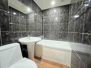 A bathroom with a white toilet, a sink, and a bathtub. - METRO MOTEL (Pocheon)