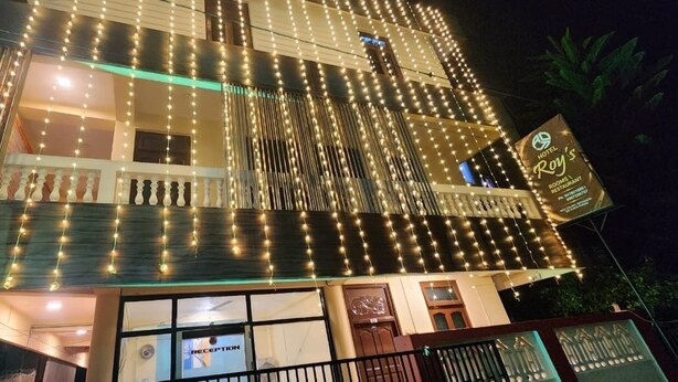 A hotel with a reception area, multiple windows, and a sign indicating it is a hotel and restaurant. - Hotel Roy's (Port Blair)