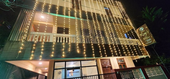 Um hotel com área de recepção, várias janelas e placa indicando que é hotel e restaurante.