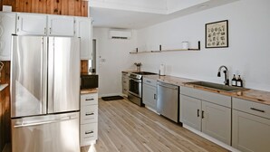 Uma cozinha moderna com eletrodomésticos de aço inoxidável, piso de madeira e design minimalista.