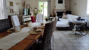 Una sala de estar bien iluminada con comedor, chimenea y televisor.