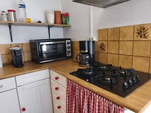 A kitchen with a microwave, coffee maker, and gas stove. - Les Chambres D’Anel - La Besbre: Guest Rooms with Pool, Terrace and Wi-Fi (Saint-Pourçain-sur-Besbre)