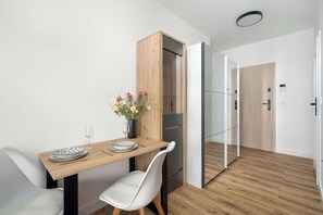 Eine moderne Küche mit einem Holzkabinett, einem Esstisch mit Stühlen und einem Kühlschrank.