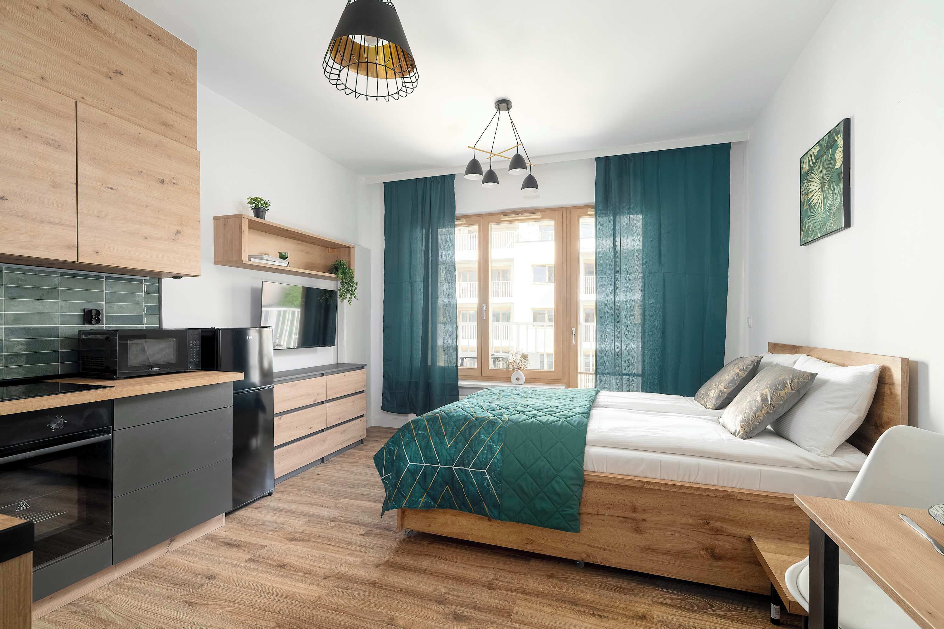 Une chambre moderne avec un lit, une table de chevet et une vue sur l’extérieur.