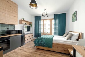 Ein modernes Schlafzimmer mit einem Bett, Nachttisch und Blick ins Freie.