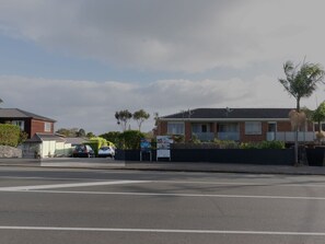 A residential street with houses, parked cars, and a 'SOLD' sign. - Walk to Beach | Sky Tower & Ocean Sunset Views | ✨Sage & Sea by Homello✨ (Devonport)