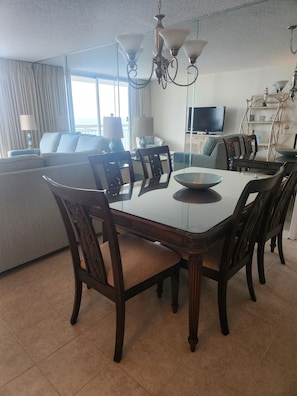 A dining area with a table, chairs, and a chandelier. - Majestic neon sunsets from the balcony of this oceanview 2bdrm 2bth condo. (Myrtle Beach)