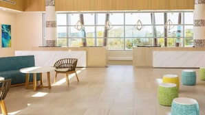 Um interior moderno com um sofá, cadeiras, uma mesa e pufes coloridos.