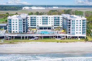 Ein mehrstöckiges Hotel mit Pool, nahe am Strand und Flughafen.