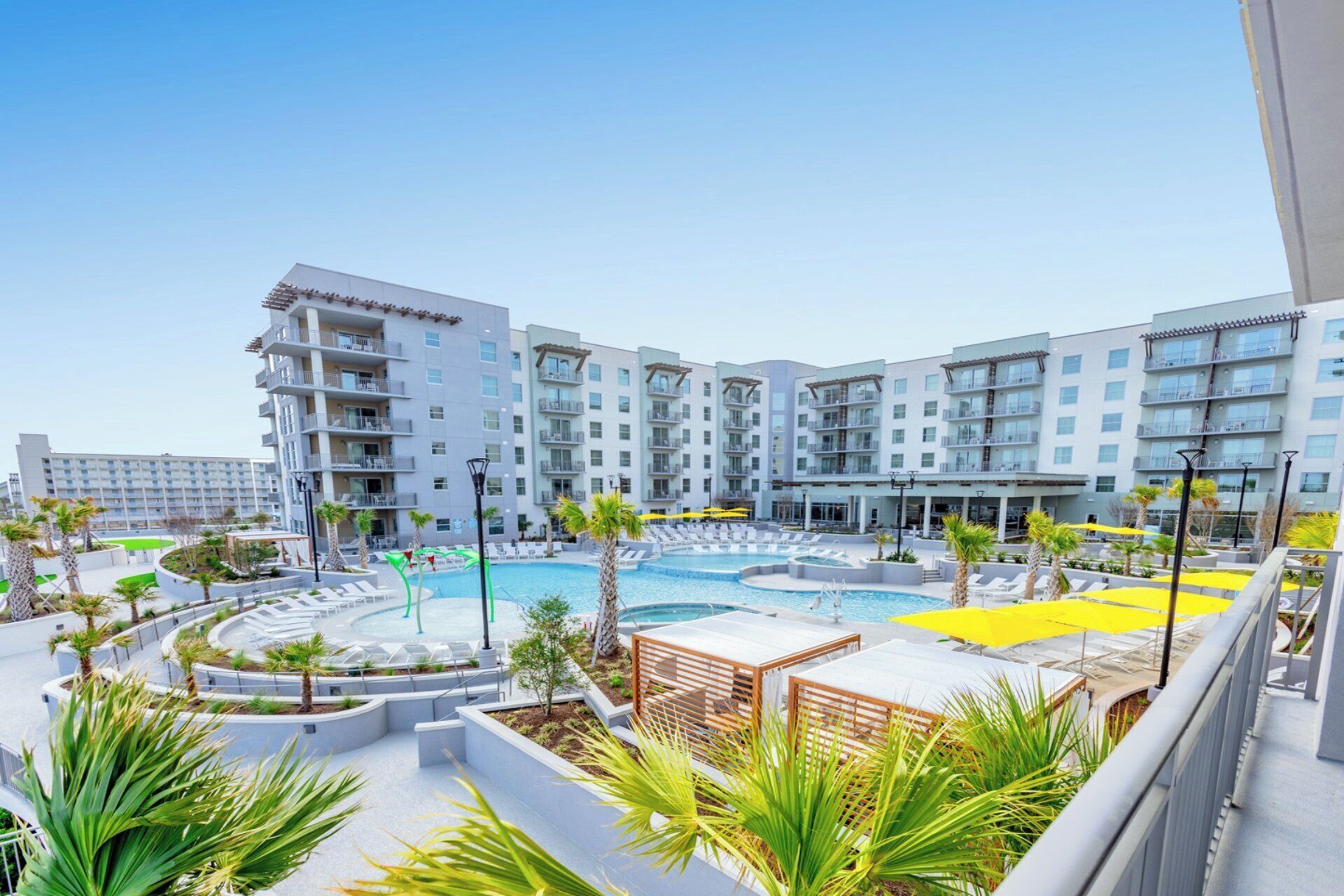 Un hôtel à plusieurs étages, doté d’une piscine et d’espaces extérieurs aménagés pour se détendre.