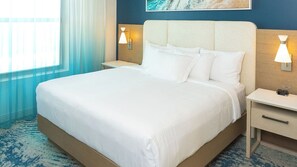 Ein Hotelzimmer mit einem großen Bett, zwei Nachttischen, einer Wandlampe und einem Nachtlicht.