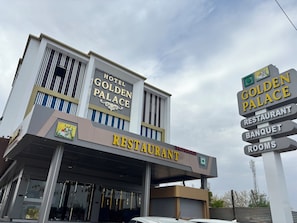 A hotel with a sign indicating it has a restaurant, banquet, and rooms.