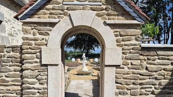 Une construction en pierre dotée d’une arche menant à une cour intérieure.