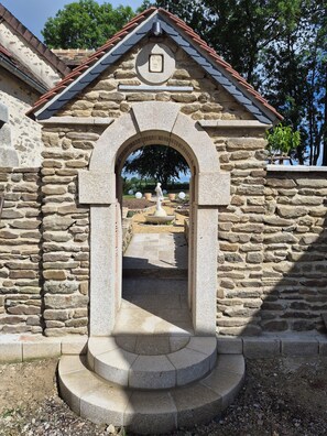 A stone structure with an archway leading to a courtyard.