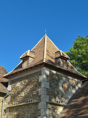 A stone building with a triangular roof and a circular window.