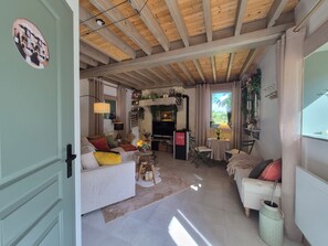 Una sala de estar acogedora con chimenea, un sofá, un televisor y un comedor con mesa y sillas.