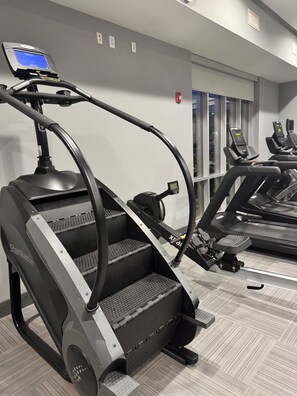 Ein Fitnessstudio mit Laufbändern und einem Steiger.