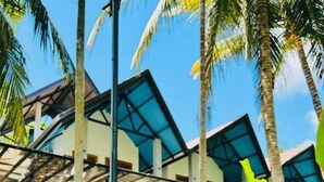A resort with outdoor seating, palm trees, and a covered patio area. - Silver Palm Resort (Anuradhapura)