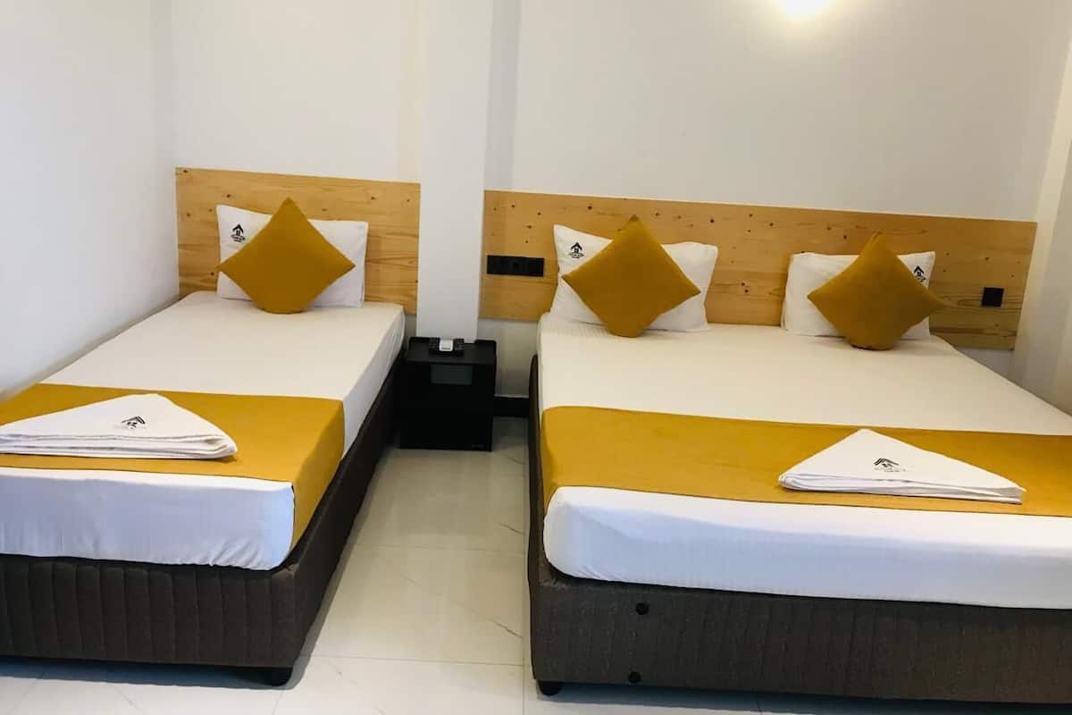 Two single beds with wooden headboards, white bedding, and yellow accents.