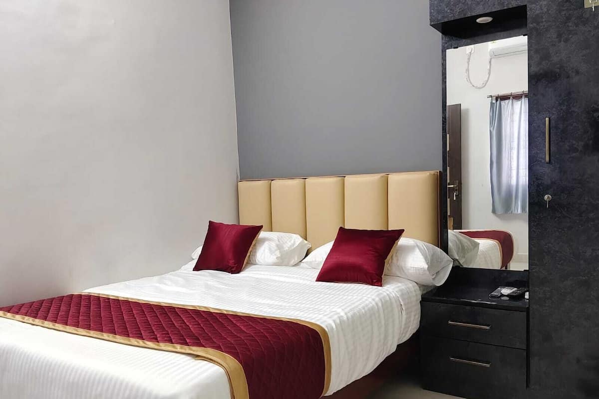 A bed with a headboard, a bedside table, and a mirror.