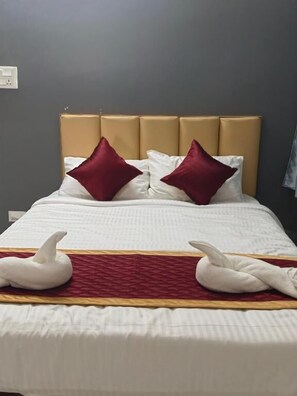 A hotel room with a bed, two pillows, a headboard, and a blanket. - Shreesree Homestay (Tiruvannamalai)