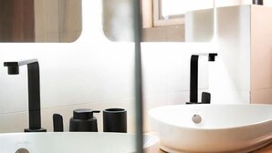 A bathroom with a white sink, black faucet, and a wooden countertop. - Résidence L'Eau Vive (Cotonou)